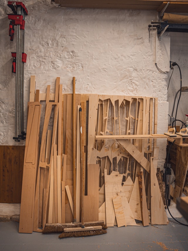 Leftover of CNC milled wood panels leaned against a wall in a workshop