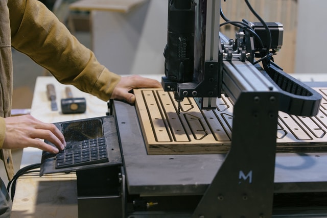 A person using the Mekanika Evo CNC milling machine after milling a batch of coat hangers.
