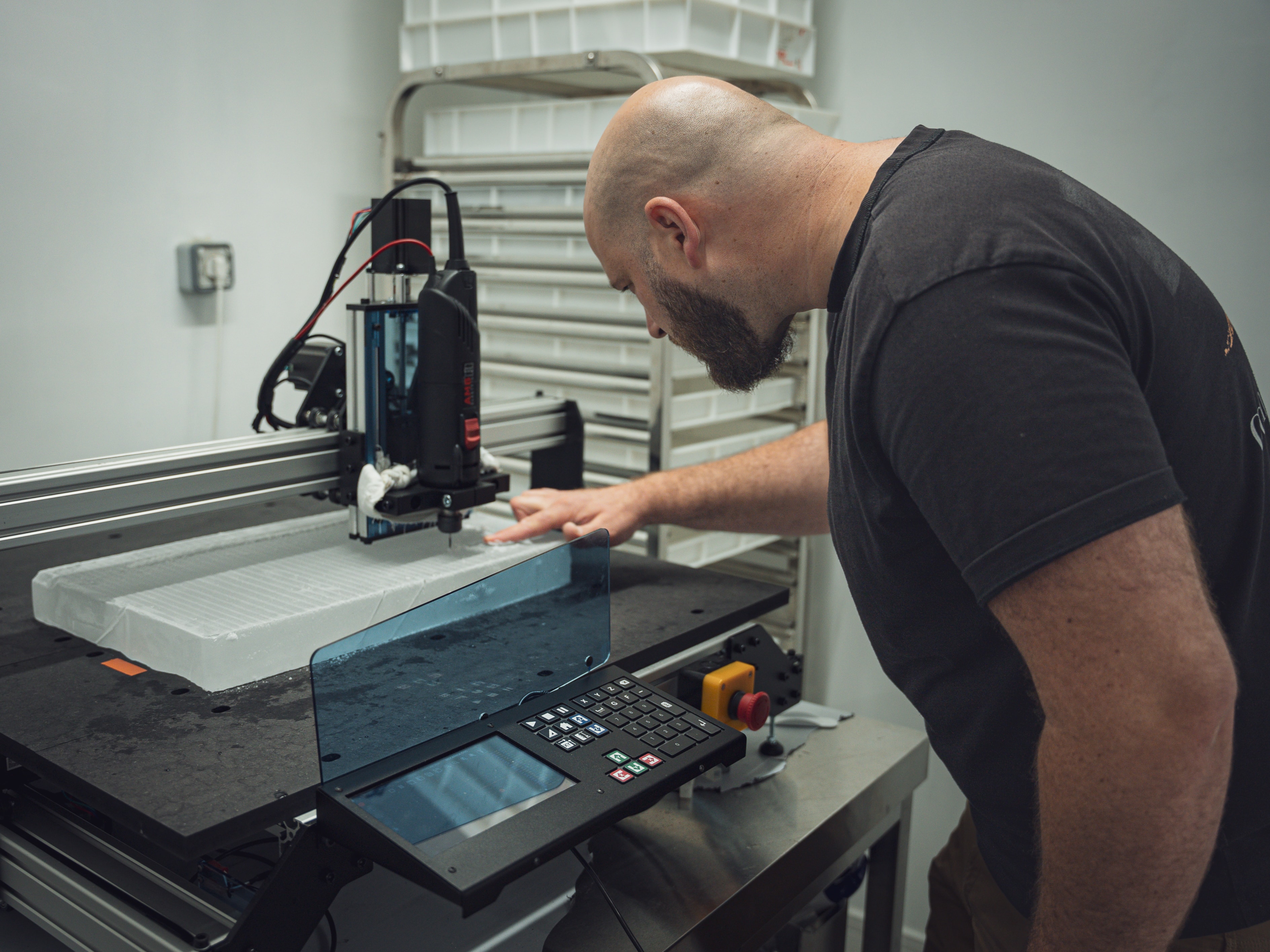 Mekanika Evo CNC milling machine milling logos on a clear ice slab and the operator checking the quality