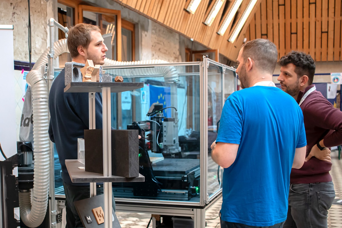 Julien and Simone from mekanika talking to a CNC machine customer on an event