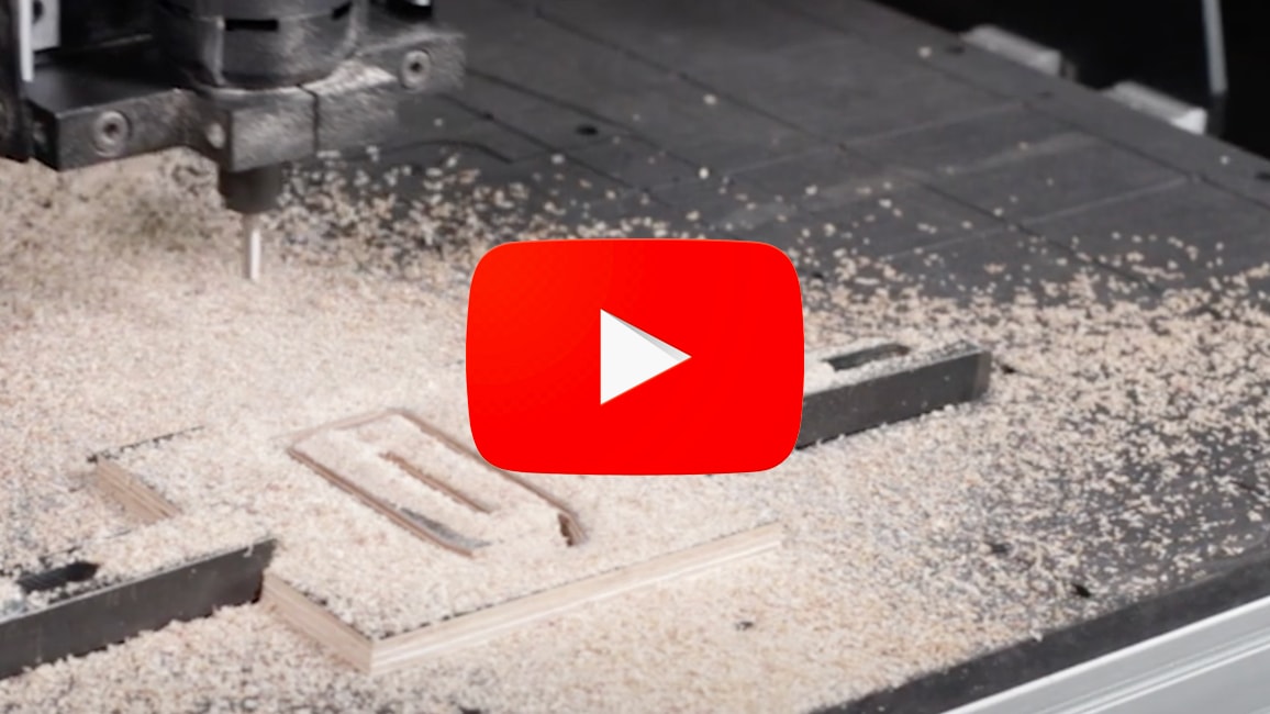 A CNC machine mills a wooden clamp