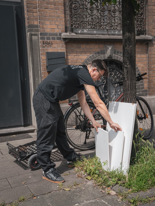 Joanie Lemercier collecting an OSB panel from the street