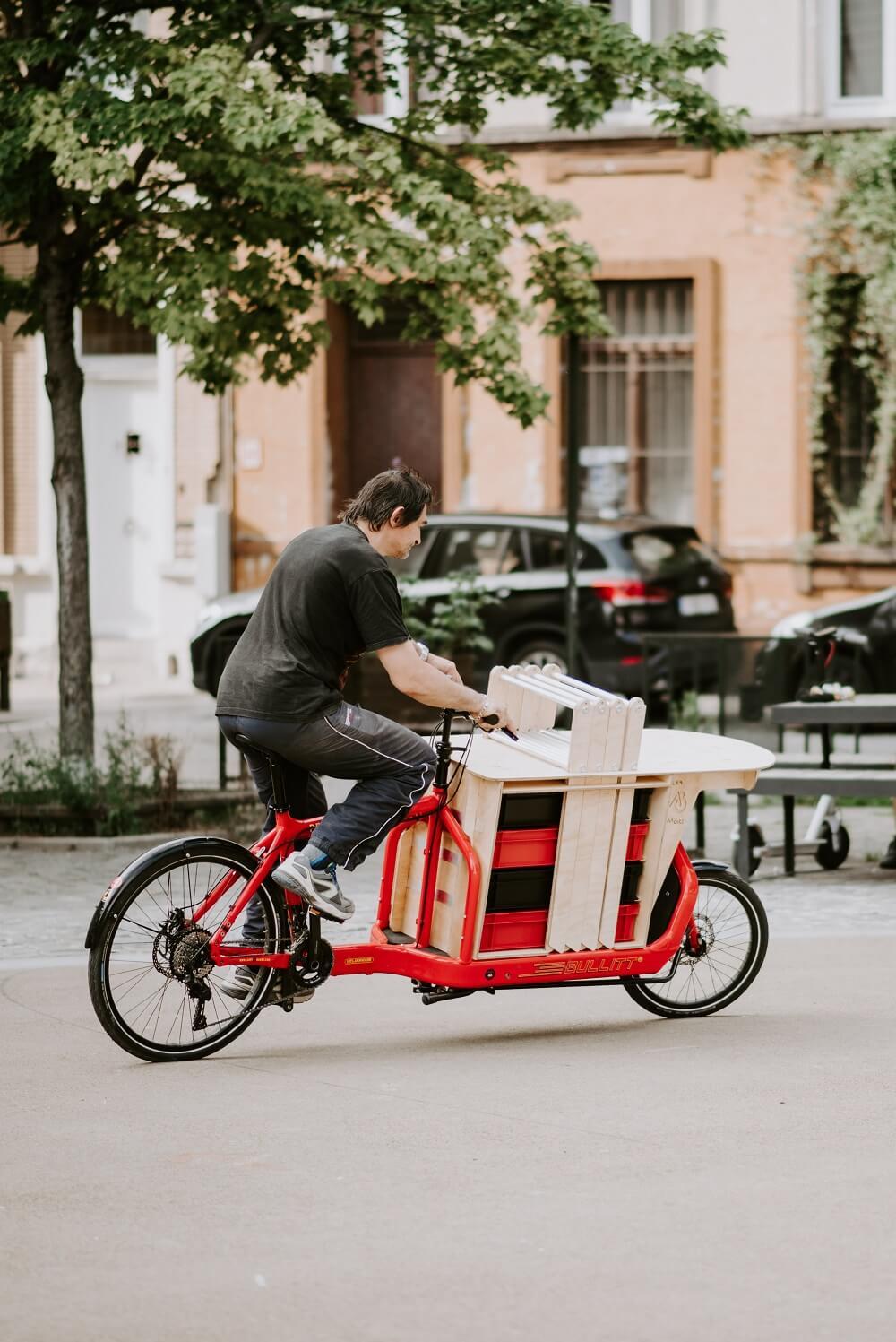 Man riding a bike equipped with cargo furniture